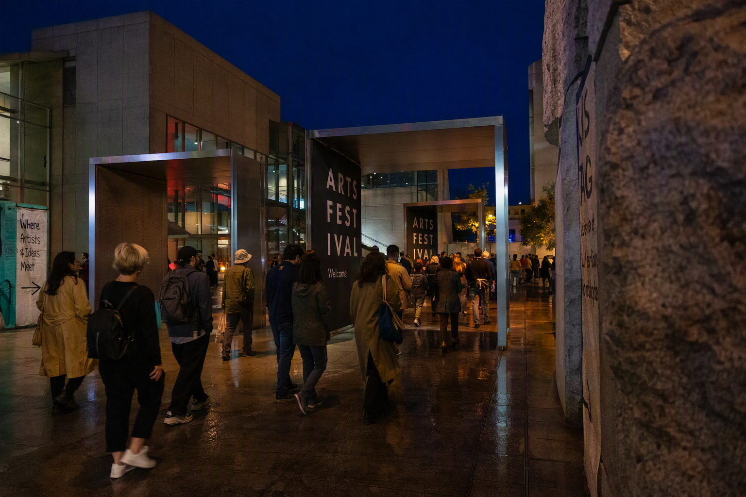 Performers moving through deep blue light and fine mist in an industrial hall